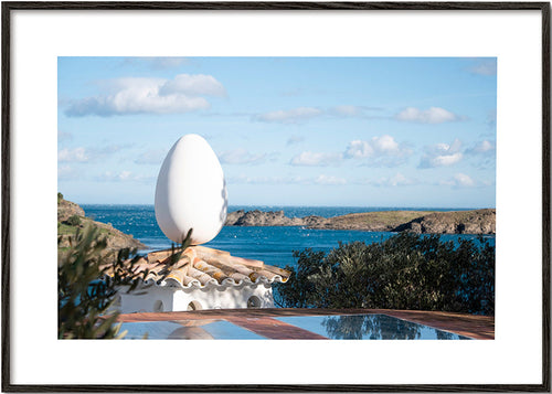 Landscape art featuring an egg sculpture by the sea