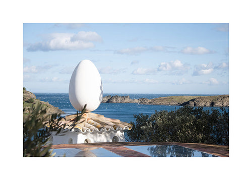Landscape art featuring an egg sculpture by the sea